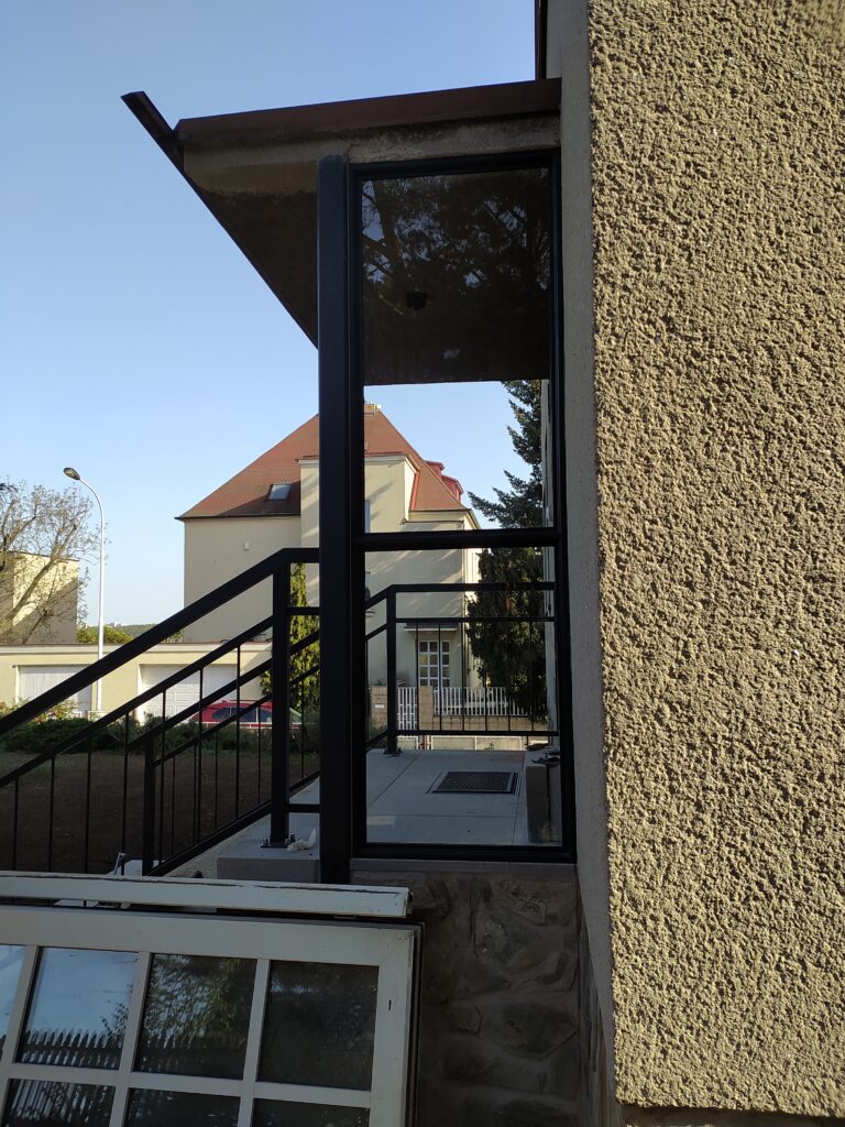Industriální skleněná stěna s kovovovým rámem